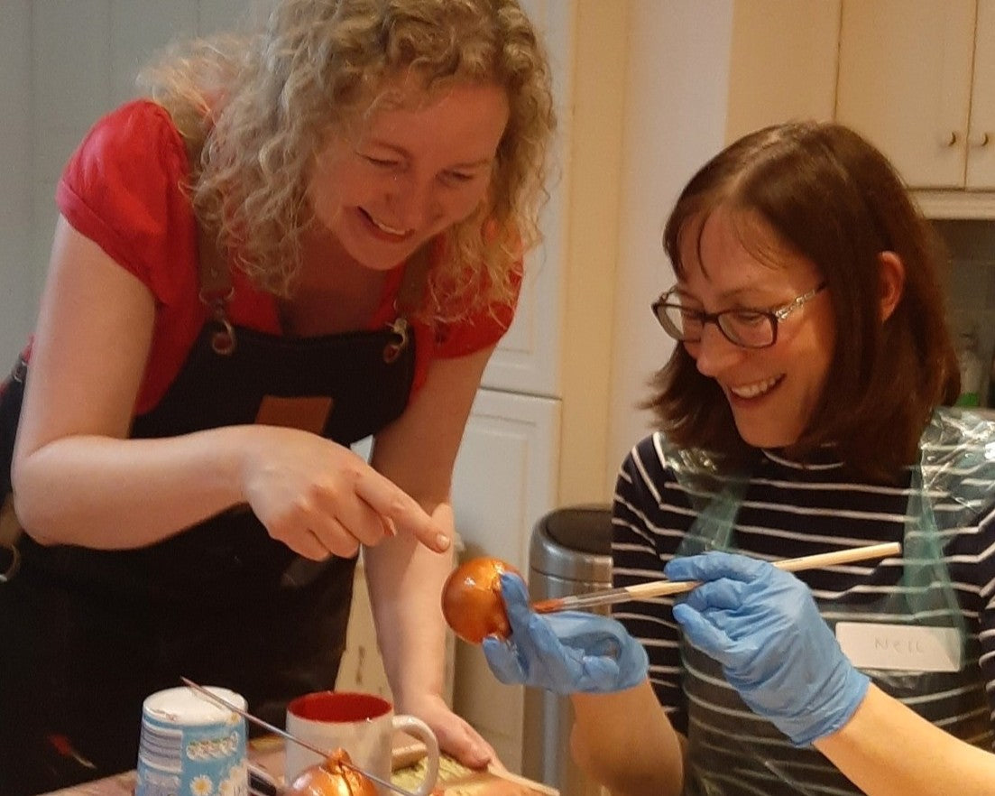 Michelle advising a Baubles & Bubbles party goer the best method to apply copper paint to her baubles.