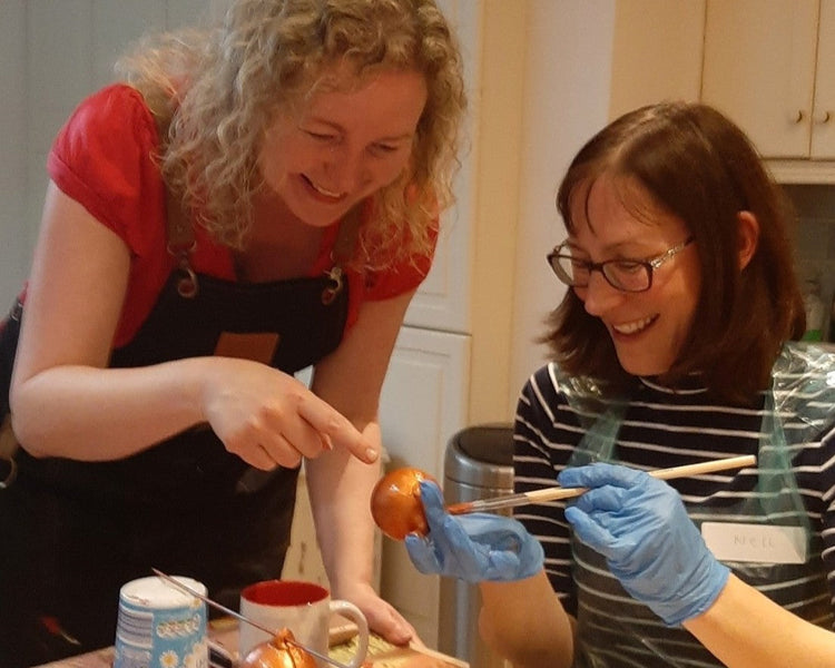 Michelle advising a Baubles & Bubbles party goer the best method to apply copper paint to her baubles.