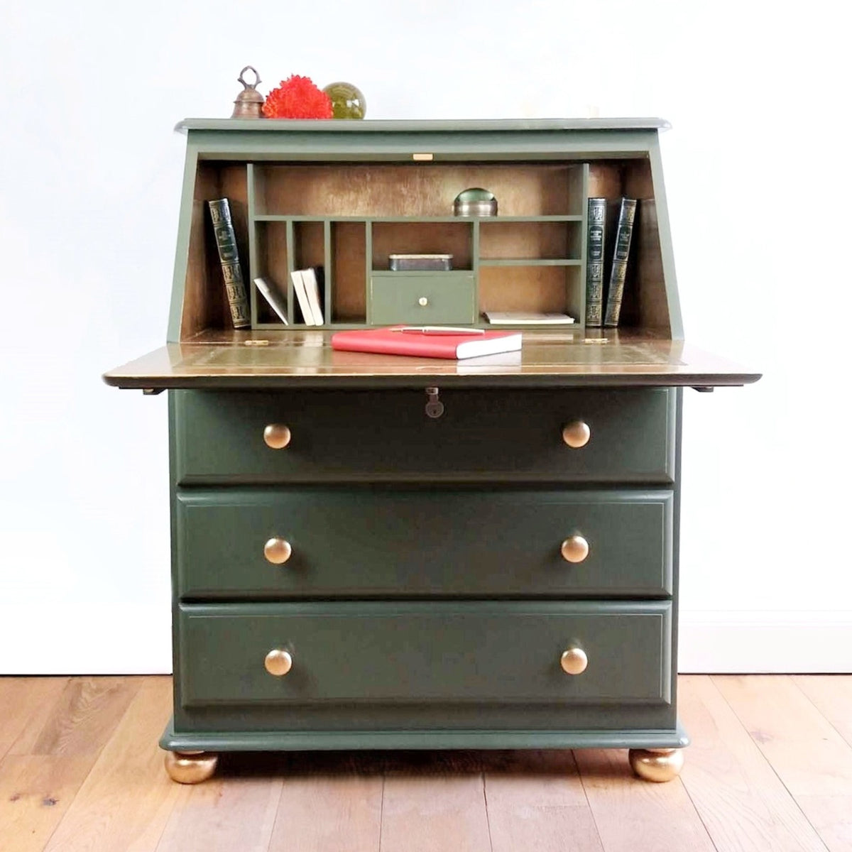 A green and gold vintage writing bureau