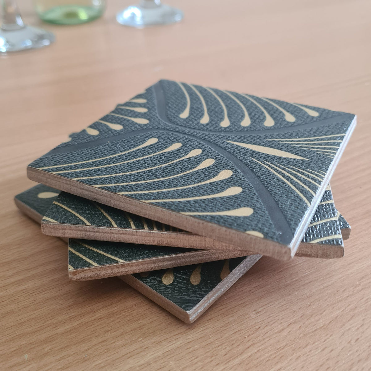 Stacked set of 4 handmade ceramic coasters featuring an elegant geometric Art Deco fan design and metallic edges