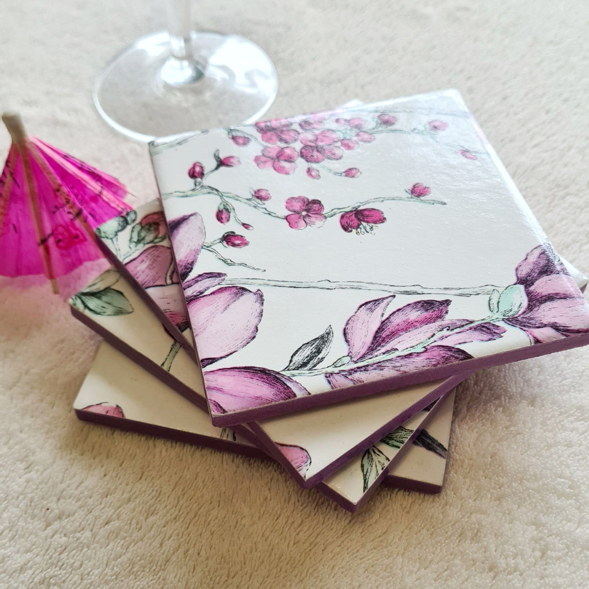 Set of four handmade Hummingbird Floral ceramic coasters stacked with metallic violet edging.