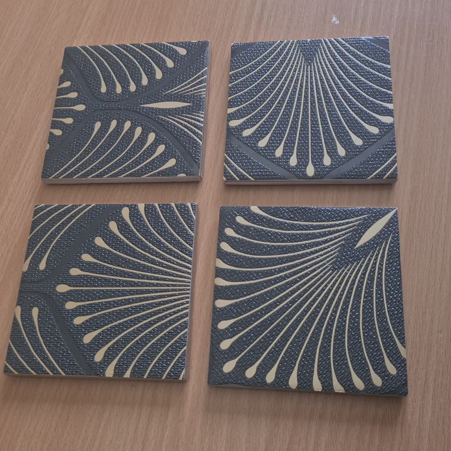 Video of set of four handmade Art Deco Fan ceramic coasters with bronze metallic edging.