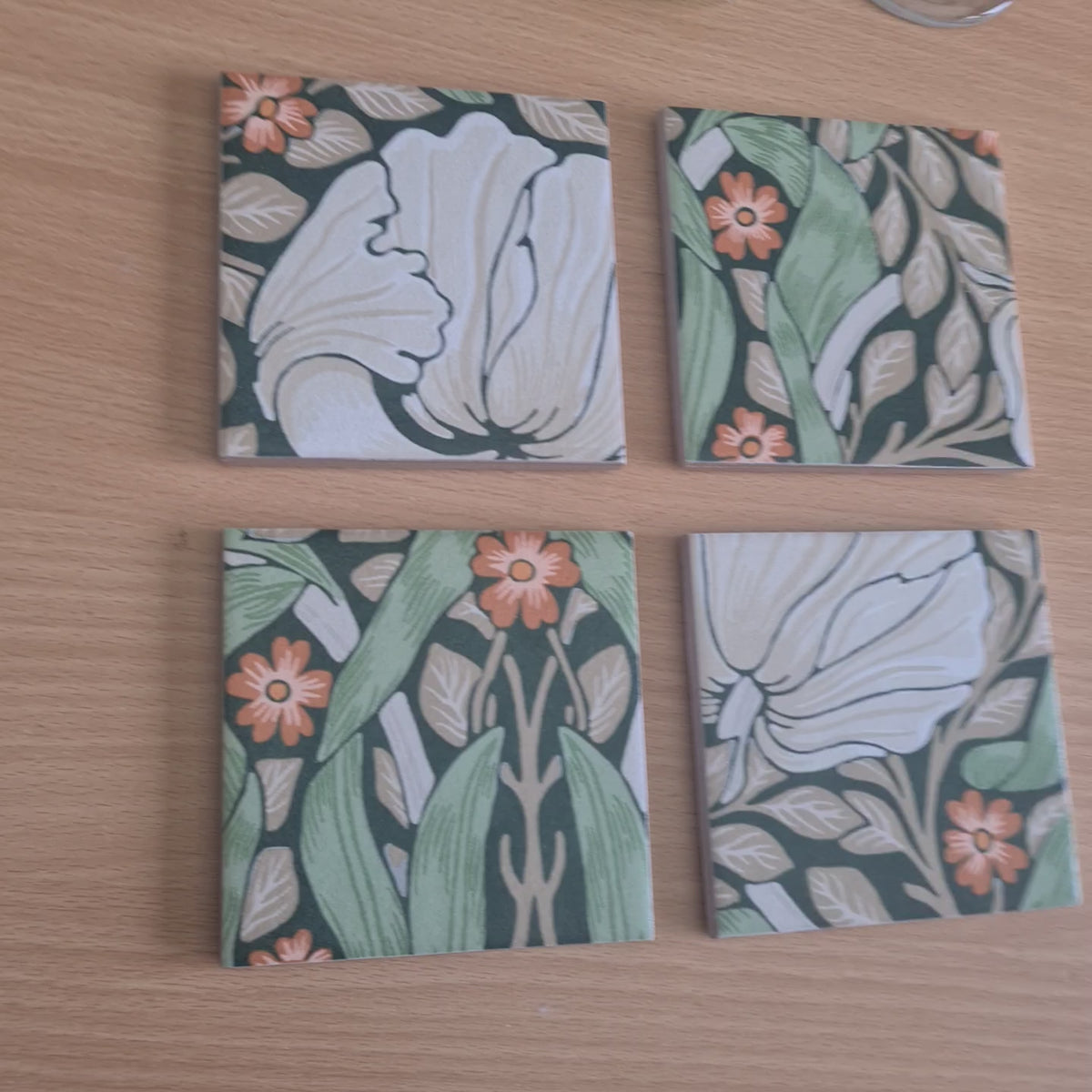 video showing William Morris pimpernel pattern handmade ceramic coasters with champagne metallic edges.