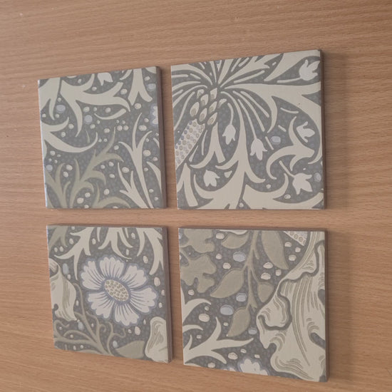 Handmade William Morris Seaweed ceramic coaster set showing the Art Nouveau design, handcrafted finish, metallic edging and cork backing.