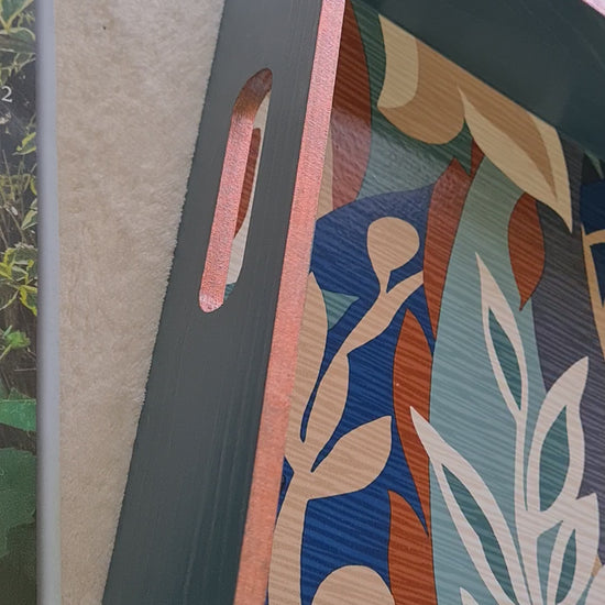 Video of Handcrafted deep teal wooden serving tray decorated with a bold retro leaf design and metallic copper edging.
