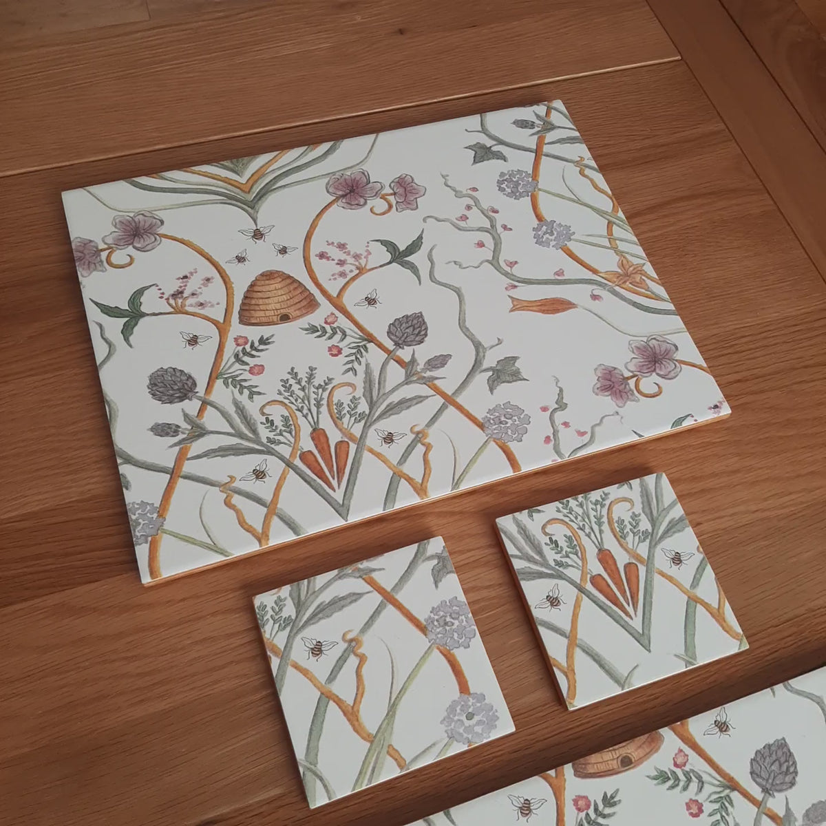 Handmade Chateau Potagerie Dinner for Two set showing two ceramic placemats, matching coasters, gold edging and individual handcrafted details.

