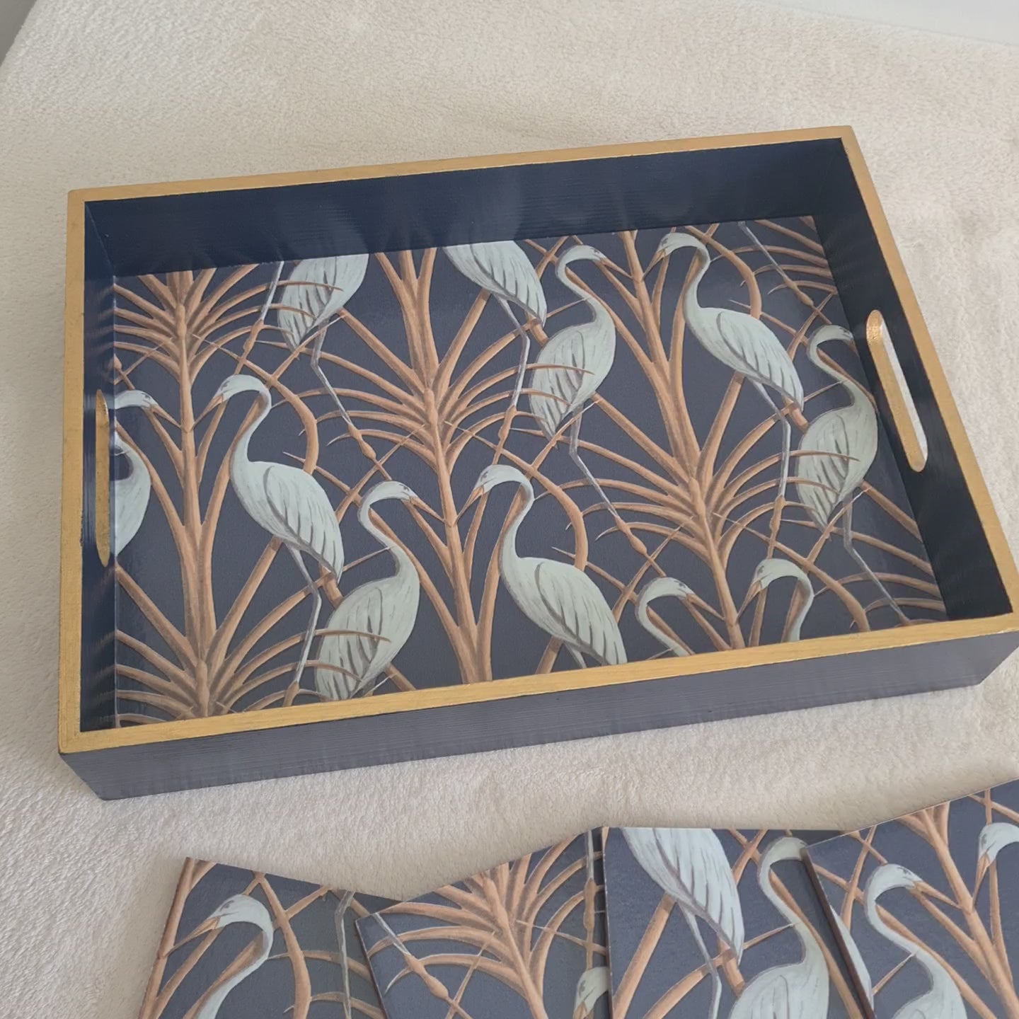 Video of handcrafted navy Nouveau Heron wooden serving tray by The Chateau Angel Strawbridge with metallic bronze edging, and matching coasters available separately.