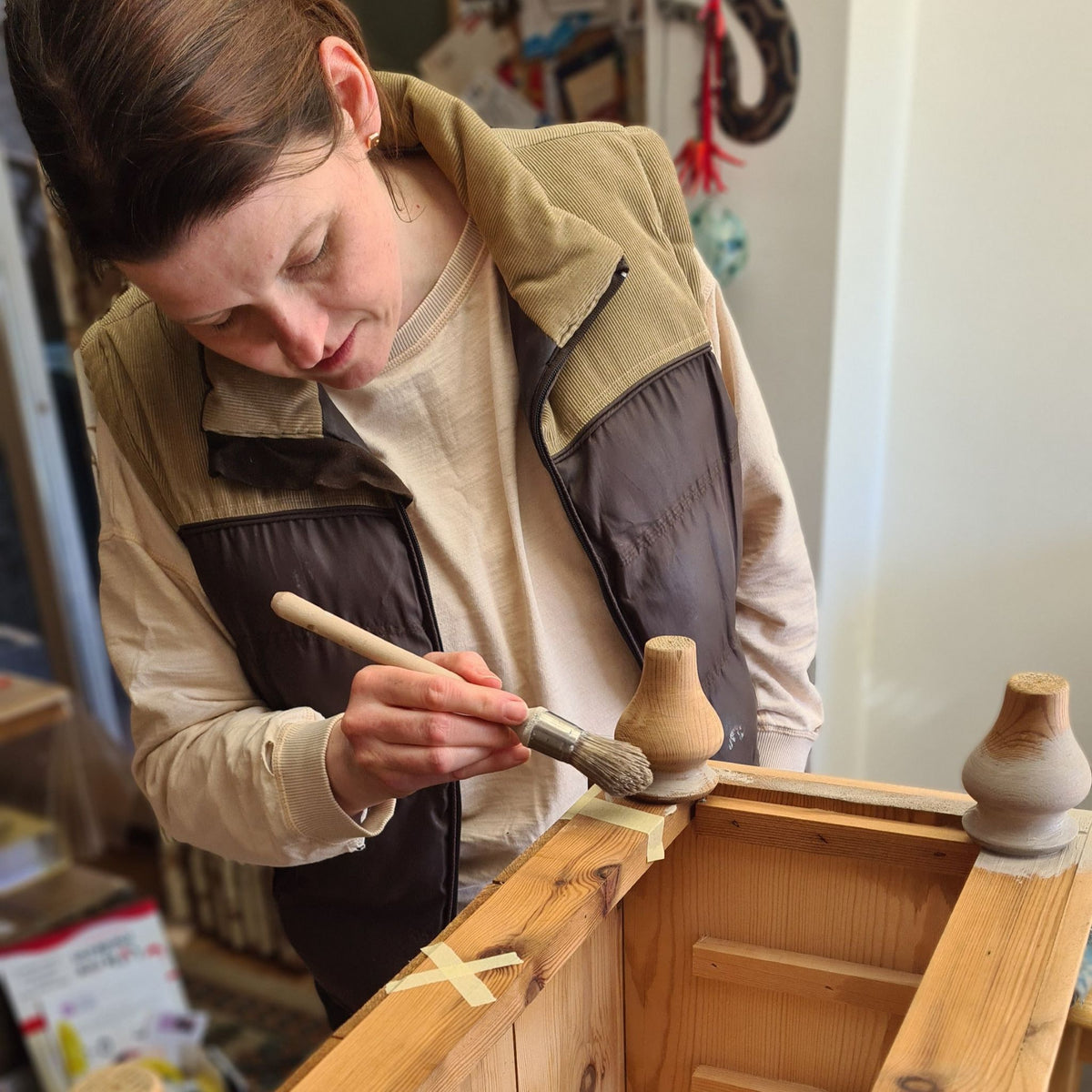 A lady learning to paint wooden furniture during a private 1-to-1 workshop at The Furniture Bureau.