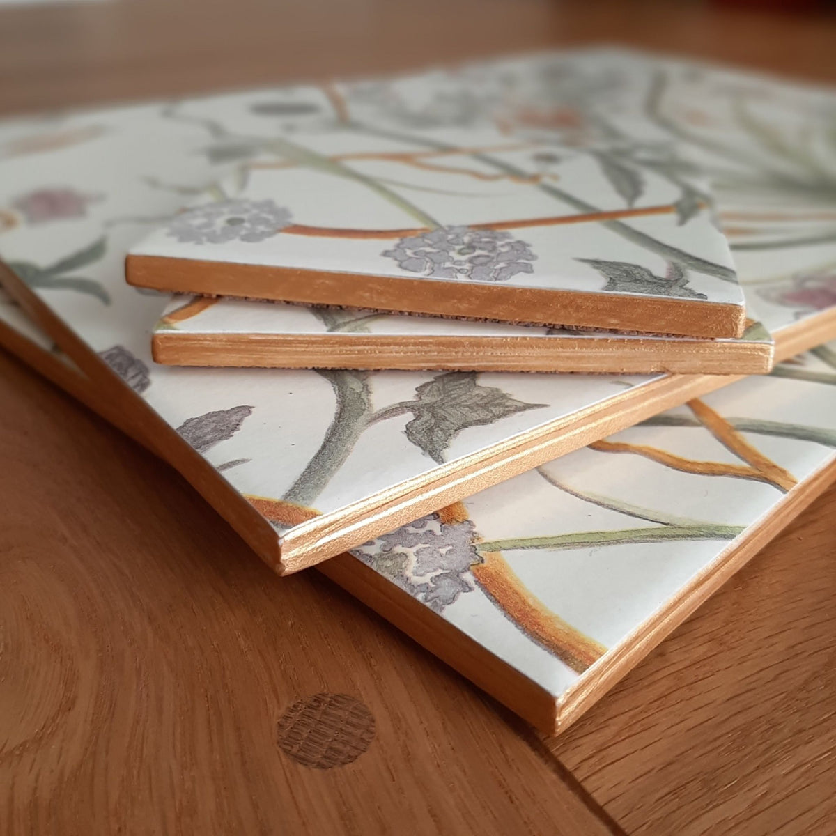 Close-up of hand-painted gold edging on a handmade Chateau Potagerie ceramic placemat and coaster set.