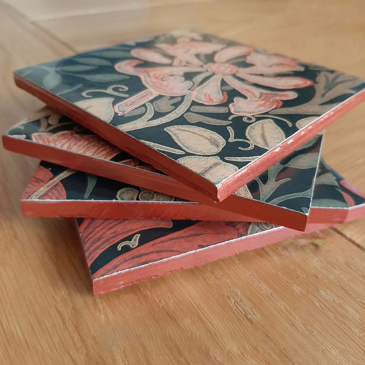 Stack of handmade William Morris Compton ceramic coasters showing their hand-finished edges.