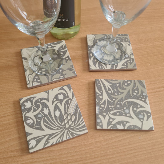 William Morris Seaweed handmade ceramic coasters styled on a coffee table with wine and glasses.